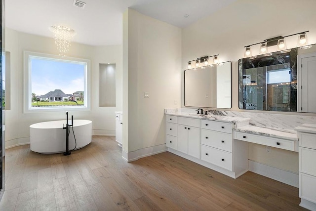 3028 Sunrise Blvd, Slidell, LA 70461 - bathroom with wood finished floors, vanity, a chandelier, and a soaking tub