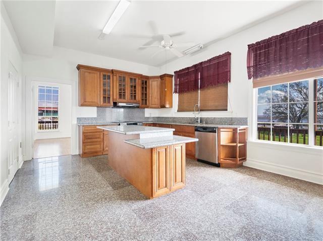30 Clinton Dr, New Orleans, LA 70129 - kitchen featuring dishwasher, brown cabinets, light countertops, a center island, and ventilation hood