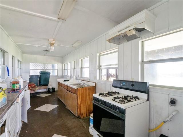 30 Clinton Dr, New Orleans, LA 70129 - kitchen featuring gas range gas stove, brown cabinets, healthy amount of natural light, and a ceiling fan