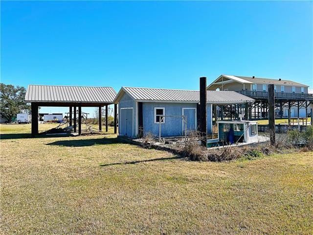 30 Clinton Dr, New Orleans, LA 70129 - back of property with a yard and a metal roof