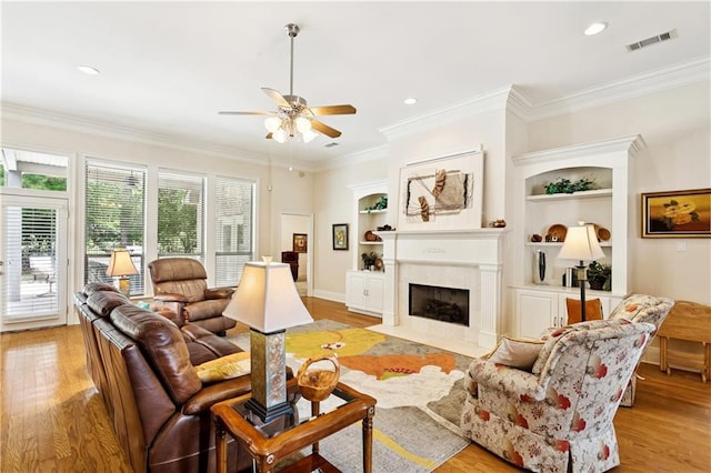 356 Aspen Ln, Covington, LA 70433 - living area with a ceiling fan, light wood-type flooring, a fireplace with flush hearth, ornamental molding, and built in features