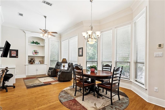 356 Aspen Ln, Covington, LA 70433 - dining space featuring healthy amount of natural light, light wood-type flooring, a ceiling fan, a chandelier, and crown molding