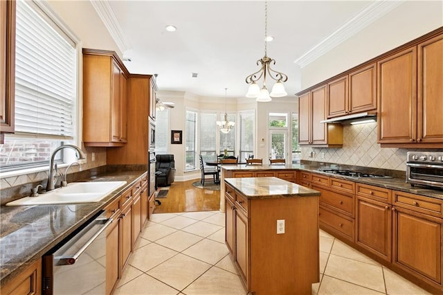356 Aspen Ln, Covington, LA 70433 - kitchen with stainless steel dishwasher, a chandelier, brown cabinetry, a peninsula, and tasteful backsplash