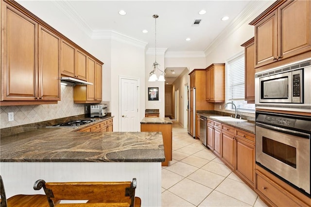 356 Aspen Ln, Covington, LA 70433 - kitchen with stainless steel appliances, a peninsula, light tile patterned floors, under cabinet range hood, and tasteful backsplash