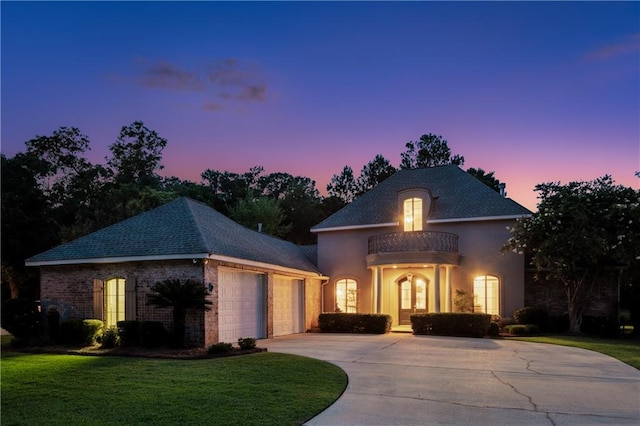 356 Aspen Ln, Covington, LA 70433 - french country home featuring an attached garage, driveway, a yard, a balcony, and stucco siding