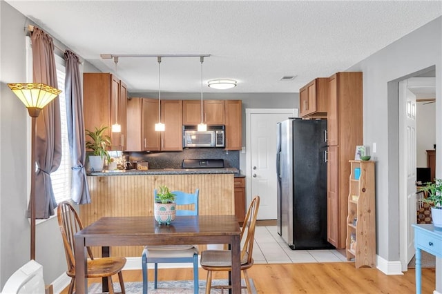 301 Rural St, River Ridge, LA 70123 - dining space with rail lighting, light wood-style floors, and a textured ceiling