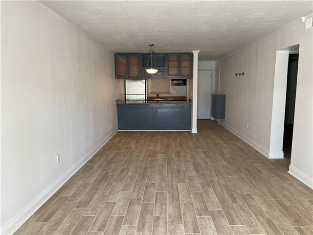 3805 Houma Blvd Unit B304, Metairie, LA 70006 - kitchen featuring fridge, dark countertops, wood finished floors, glass insert cabinets, and pendant lighting