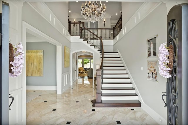 21 Royal Palm Dr, Kenner, LA 70065 - foyer with stairs, marble tiled flooring, a towering ceiling, arched walkways, and a chandelier