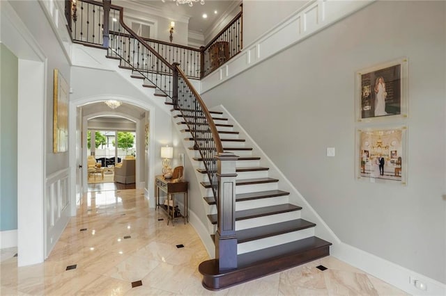 21 Royal Palm Dr, Kenner, LA 70065 - stairs featuring arched walkways, a towering ceiling, marble tiled floors, and ornamental molding