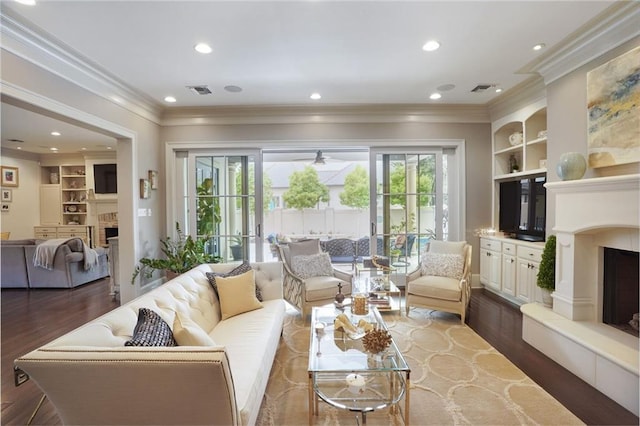 21 Royal Palm Dr, Kenner, LA 70065 - living room featuring a fireplace with raised hearth, built in features, wood finished floors, crown molding, and recessed lighting