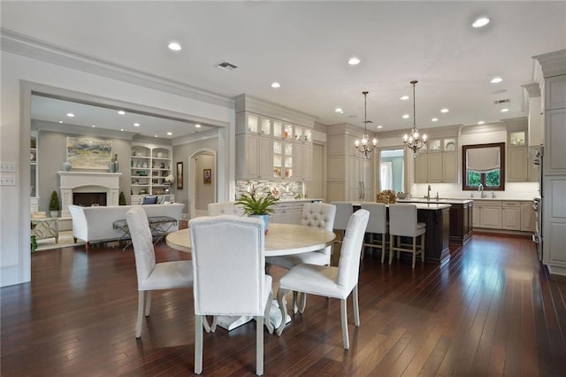 21 Royal Palm Dr, Kenner, LA 70065 - dining room with a chandelier, crown molding, a fireplace, dark wood-style floors, and recessed lighting