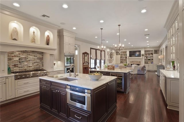 21 Royal Palm Dr, Kenner, LA 70065 - kitchen featuring a center island with sink, beverage cooler, stainless steel appliances, a chandelier, and recessed lighting