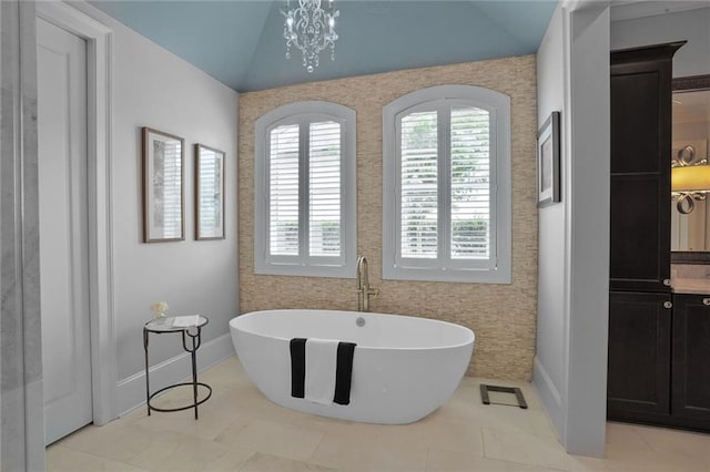21 Royal Palm Dr, Kenner, LA 70065 - bathroom with vaulted ceiling, a soaking tub, plenty of natural light, a chandelier, and vanity