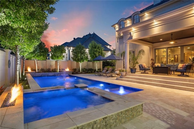 21 Royal Palm Dr, Kenner, LA 70065 - pool at dusk with a patio, an outdoor living space with a fire pit, a fenced backyard, and a pool with connected hot tub