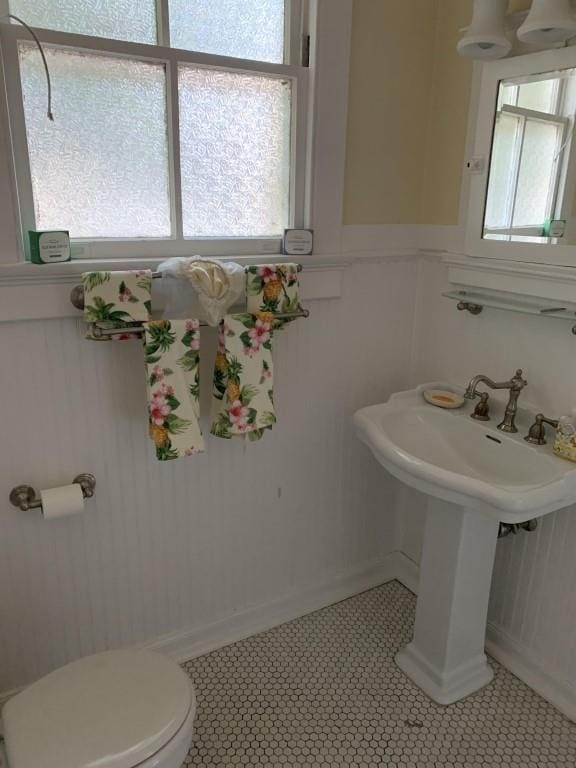 2527 Calhoun St, New Orleans, LA 70118 - bathroom featuring healthy amount of natural light, a decorative wall, and wainscoting