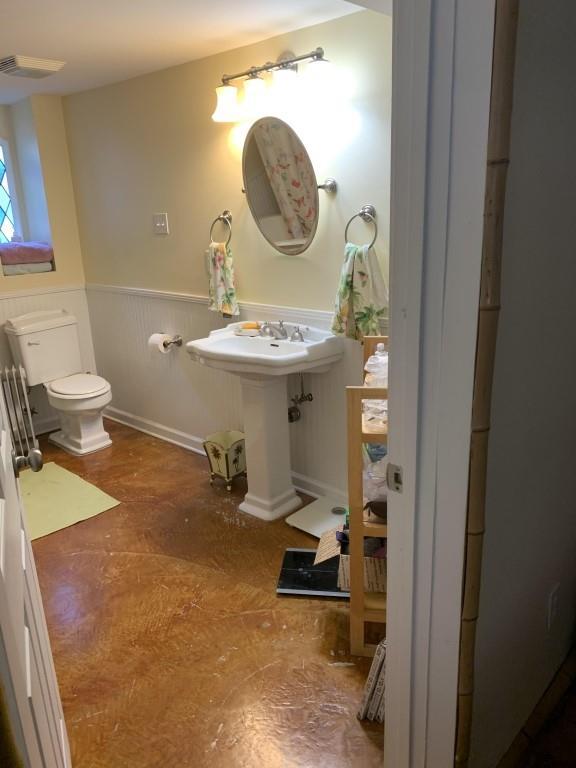 2527 Calhoun St, New Orleans, LA 70118 - bathroom featuring toilet and a wainscoted wall