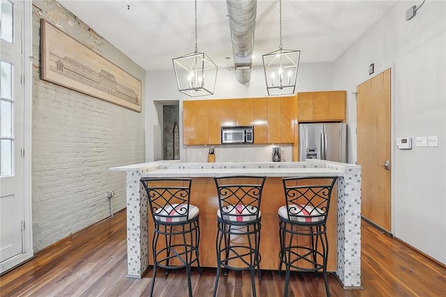 1140 Decatur St Unit 3, New Orleans, LA 70116 - kitchen with appliances with stainless steel finishes, dark wood-style flooring, light countertops, a kitchen island, and brown cabinets