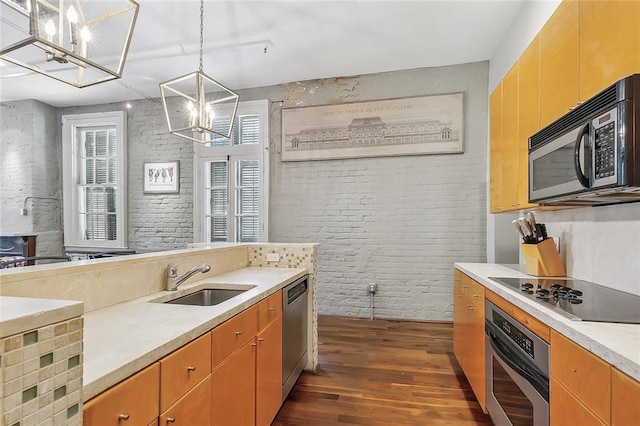 1140 Decatur St Unit 3, New Orleans, LA 70116 - kitchen with black appliances, a chandelier, dark wood-style flooring, brick wall, and light countertops