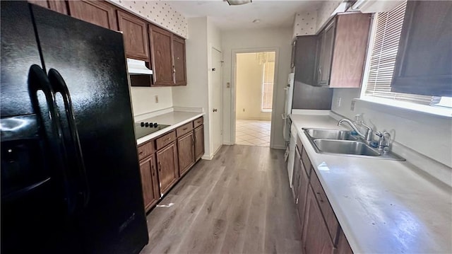 5761 Carlisle Ct, New Orleans, LA 70131 - kitchen featuring black appliances, under cabinet range hood, light wood finished floors, and light countertops