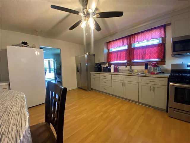 8007 Drum St, New Orleans, LA 70126 - kitchen featuring stainless steel appliances, healthy amount of natural light, light wood finished floors, and ceiling fan