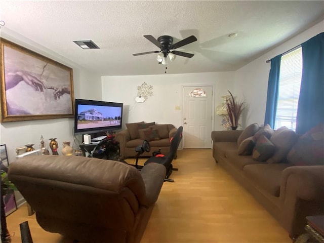 8007 Drum St, New Orleans, LA 70126 - living room with light wood-style floors, a textured ceiling, and a ceiling fan