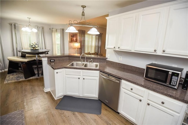 43126 Pecan Ridge Dr, Hammond, LA 70403 - kitchen featuring stainless steel appliances, white cabinetry, light wood-style flooring, a chandelier, and a peninsula