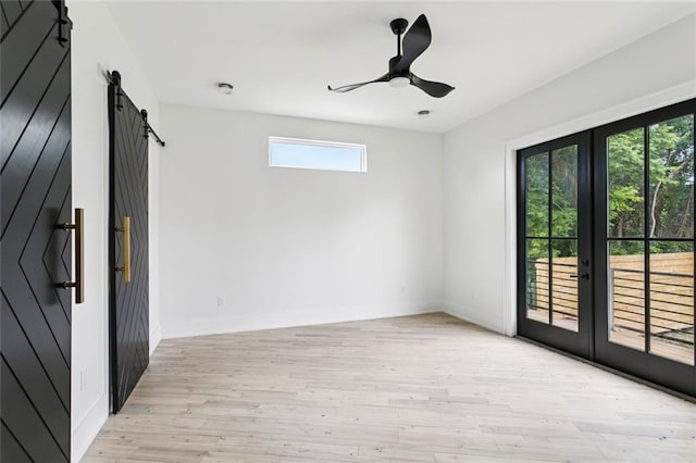 5651 W End Blvd, New Orleans, LA 70124 - spare room featuring a barn door, light wood finished floors, french doors, and ceiling fan