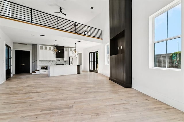 5651 W End Blvd, New Orleans, LA 70124 - unfurnished living room with a towering ceiling, light wood-style flooring, and a chandelier