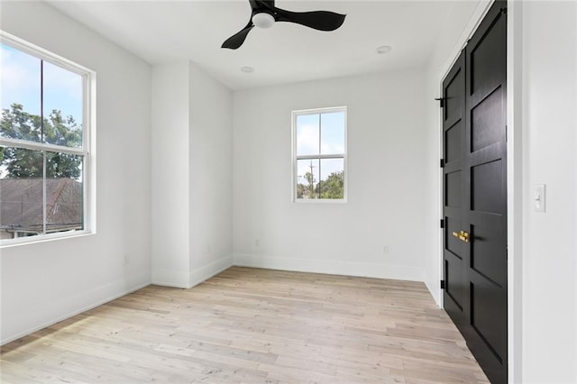 5651 W End Blvd, New Orleans, LA 70124 - unfurnished bedroom with light wood-style floors, a barn door, and a ceiling fan