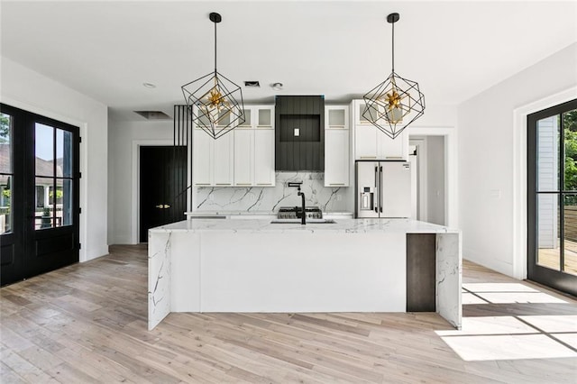5651 W End Blvd, New Orleans, LA 70124 - kitchen featuring refrigerator with ice dispenser, a chandelier, a large island, tasteful backsplash, and light wood-style floors