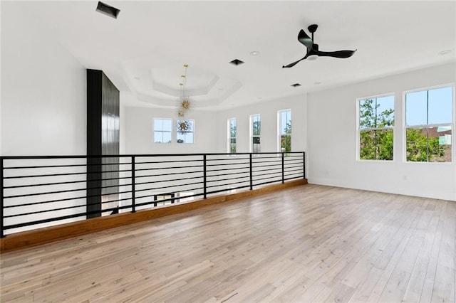 5651 W End Blvd, New Orleans, LA 70124 - unfurnished room with light wood-type flooring, ceiling fan, a chandelier, and a raised ceiling