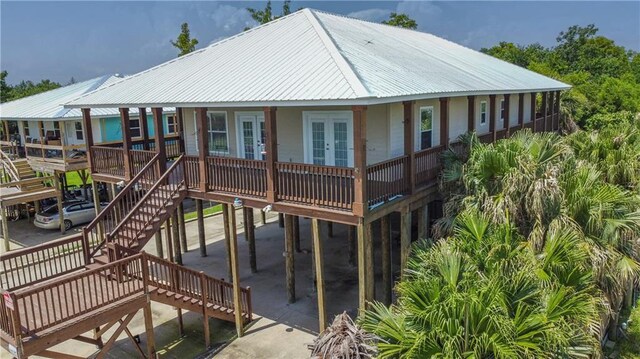 121 Pontchartrain Rd, La Place, LA 70068 - view of front facade featuring french doors, a metal roof, stairs, and a carport