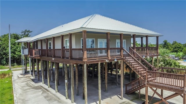 121 Pontchartrain Rd, La Place, LA 70068 - view of front of home featuring a carport, stairway, a metal roof, and covered porch