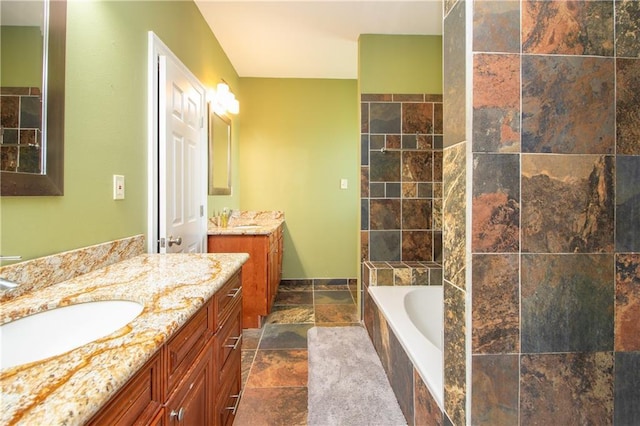 121 Pontchartrain Rd, La Place, LA 70068 - bathroom featuring stone tile flooring, a relaxing tiled tub, and two vanities