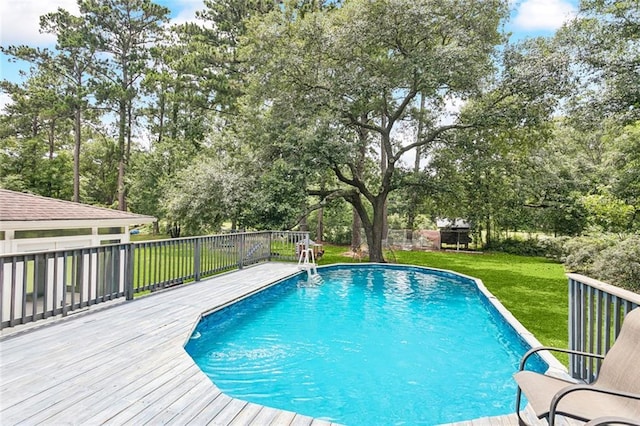 314 Royal Dr, Slidell, LA 70460 - outdoor pool with a deck, view of wooded area, and a lawn