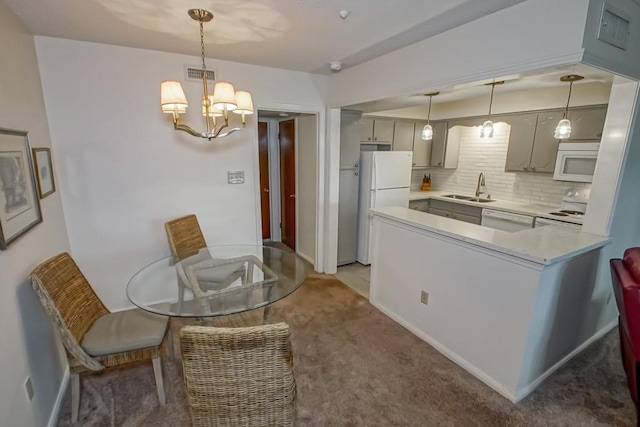 2708 Whitney Pl Unit 901, Metairie, LA 70002 - kitchen with white appliances, light carpet, decorative backsplash, a chandelier, and light countertops