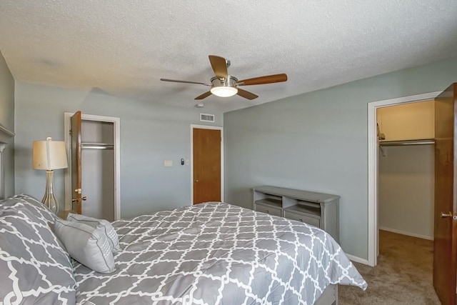 2708 Whitney Pl Unit 901, Metairie, LA 70002 - bedroom with a closet, carpet, a walk in closet, a ceiling fan, and a textured ceiling
