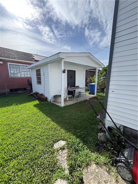 242830 A P Tureaud Ave, New Orleans, LA 70119 - rear view of property featuring a lawn and a patio area