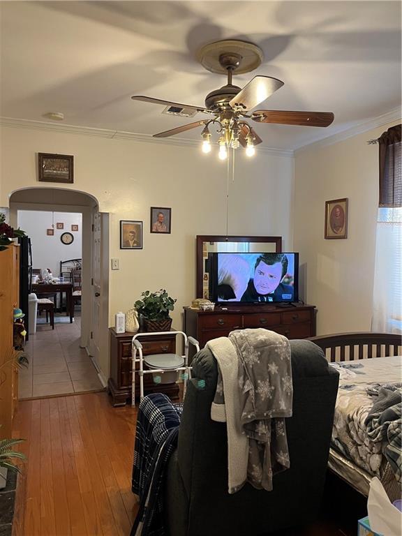 242830 A P Tureaud Ave, New Orleans, LA 70119 - living area with a ceiling fan, crown molding, wood-type flooring, and arched walkways