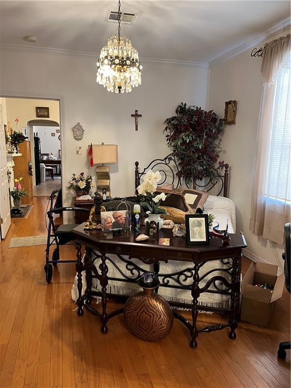 242830 A P Tureaud Ave, New Orleans, LA 70119 - dining area featuring wood-type flooring, healthy amount of natural light, ornamental molding, a chandelier, and arched walkways