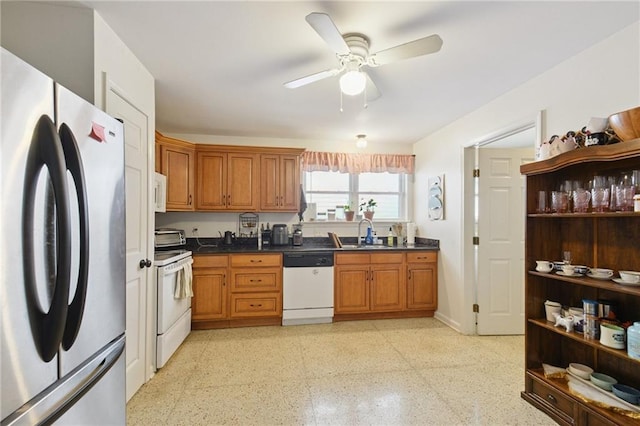 685759 Vicksburg St, New Orleans, LA 70124 - kitchen featuring white appliances, brown cabinetry, a ceiling fan, dark speckled floor, and dark countertops
