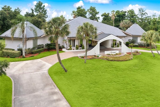 738 English Turn Ln, New Orleans, LA 70131 - view of front of house with curved driveway, stucco siding, and a front yard