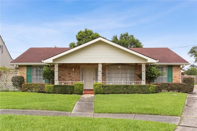 142 E Randall Ct, Gretna, LA 70053 - view of front of house with brick siding, a front lawn, covered porch, and roof with shingles