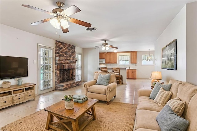 142 E Randall Ct, Gretna, LA 70053 - living room with light tile patterned floors, ceiling fan, and a fireplace