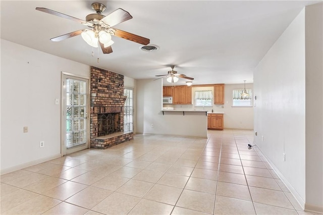 142 E Randall Ct, Gretna, LA 70053 - unfurnished living room with light tile patterned floors, a brick fireplace, ceiling fan, and a chandelier
