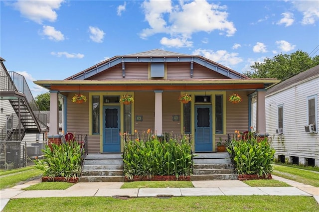 53941 Angela St, Arabi, LA 70032 - view of front of property featuring a porch, cooling unit, and a front lawn