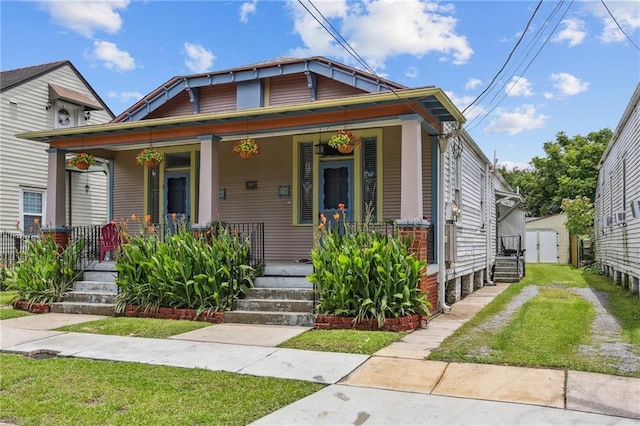 53941 Angela St, Arabi, LA 70032 - view of front of home with a porch, a shed, and a front yard