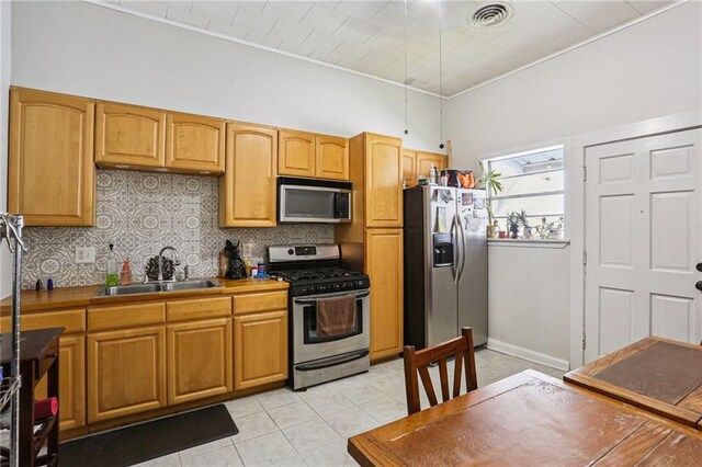 53941 Angela St, Arabi, LA 70032 - kitchen featuring appliances with stainless steel finishes, decorative backsplash, and light tile patterned floors