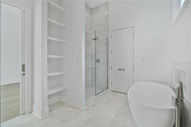 5310 Laurel St, New Orleans, LA 70115 - bathroom with a stall shower, built in shelves, a soaking tub, and marble look tile flooring