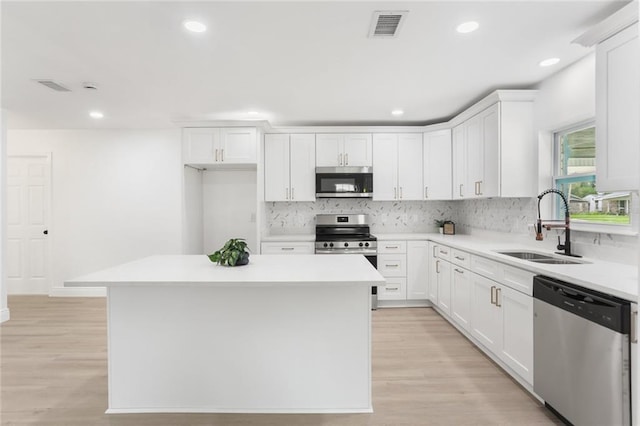 313 Post Dr, Luling, LA 70070 - kitchen with stainless steel appliances, tasteful backsplash, white cabinetry, light countertops, and recessed lighting